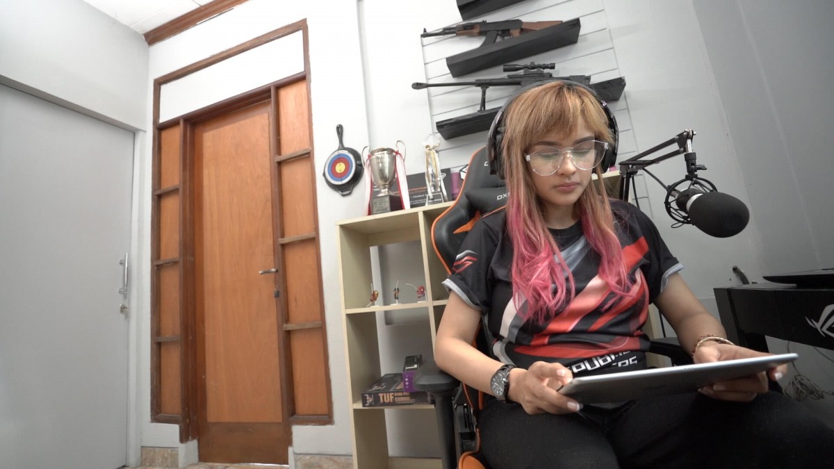 Ridha Audrey tampak fokus menggunakan iPad dan headphone